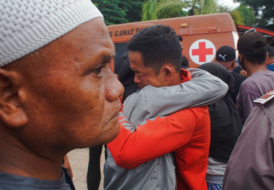 Two people comfort each other in the aftermath of the earthquake.