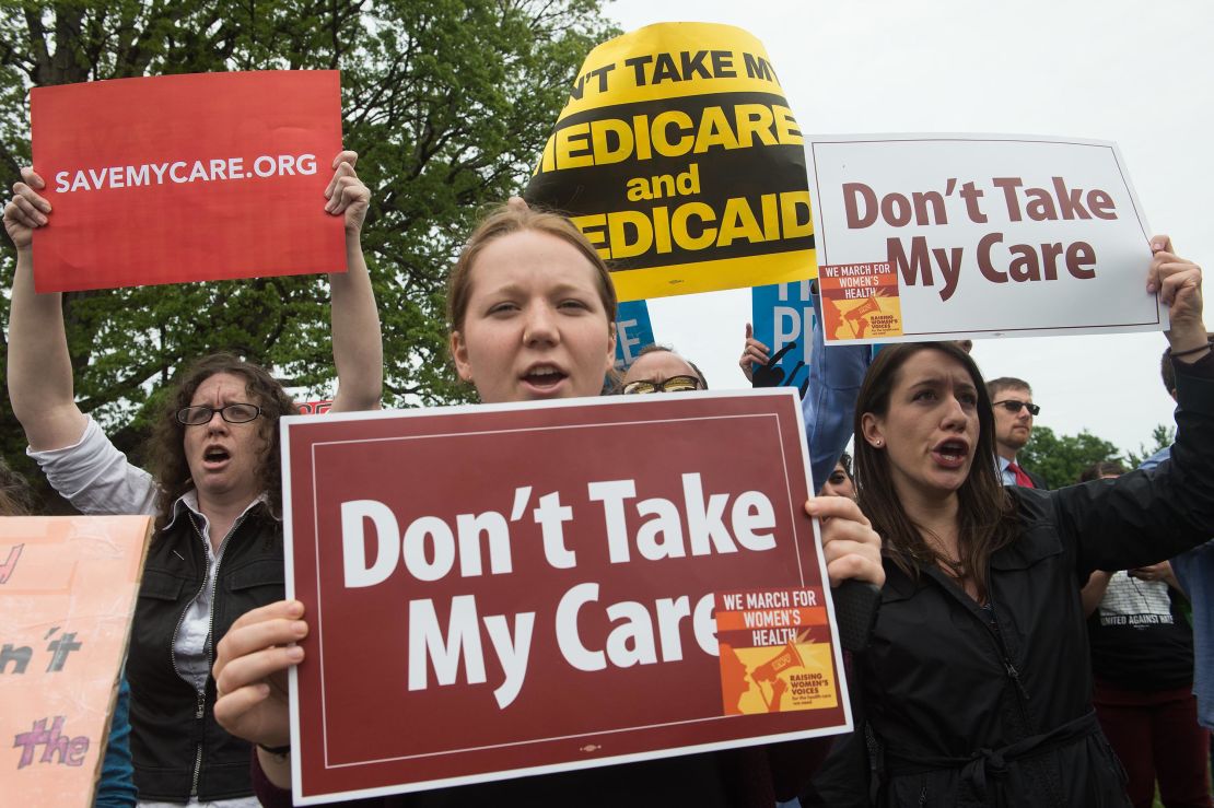 Protesters hold signs and shout at lawmakers walking out of the US Capitol. 