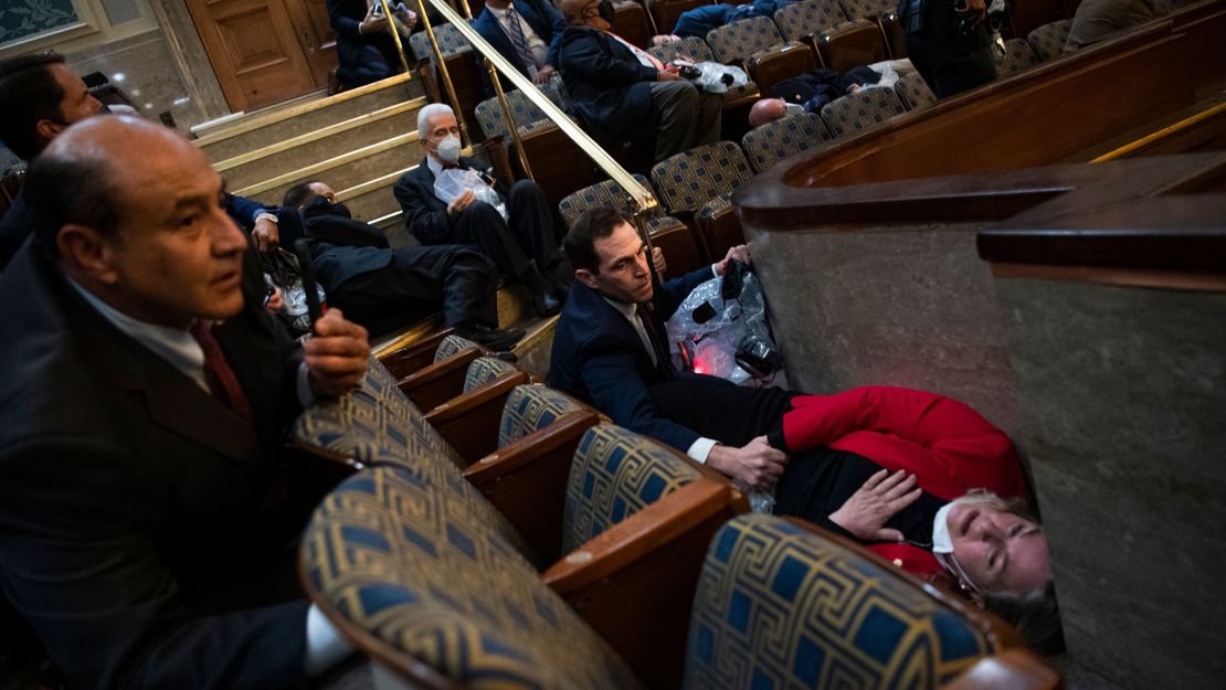 Rep. Jason Crow, a Colorado Democrat, comforts Rep. Susan Wild, a Pennsylvania Democrat, while taking cover as rioters seiged the US Capitol on January 6.