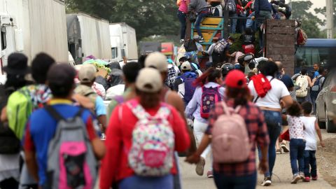 Members of a migrant caravan jump on a truck on their way to the Guatemalan border as part of their journey toward the United States on January 15, 2021, in San Pedro Sula, Honduras.