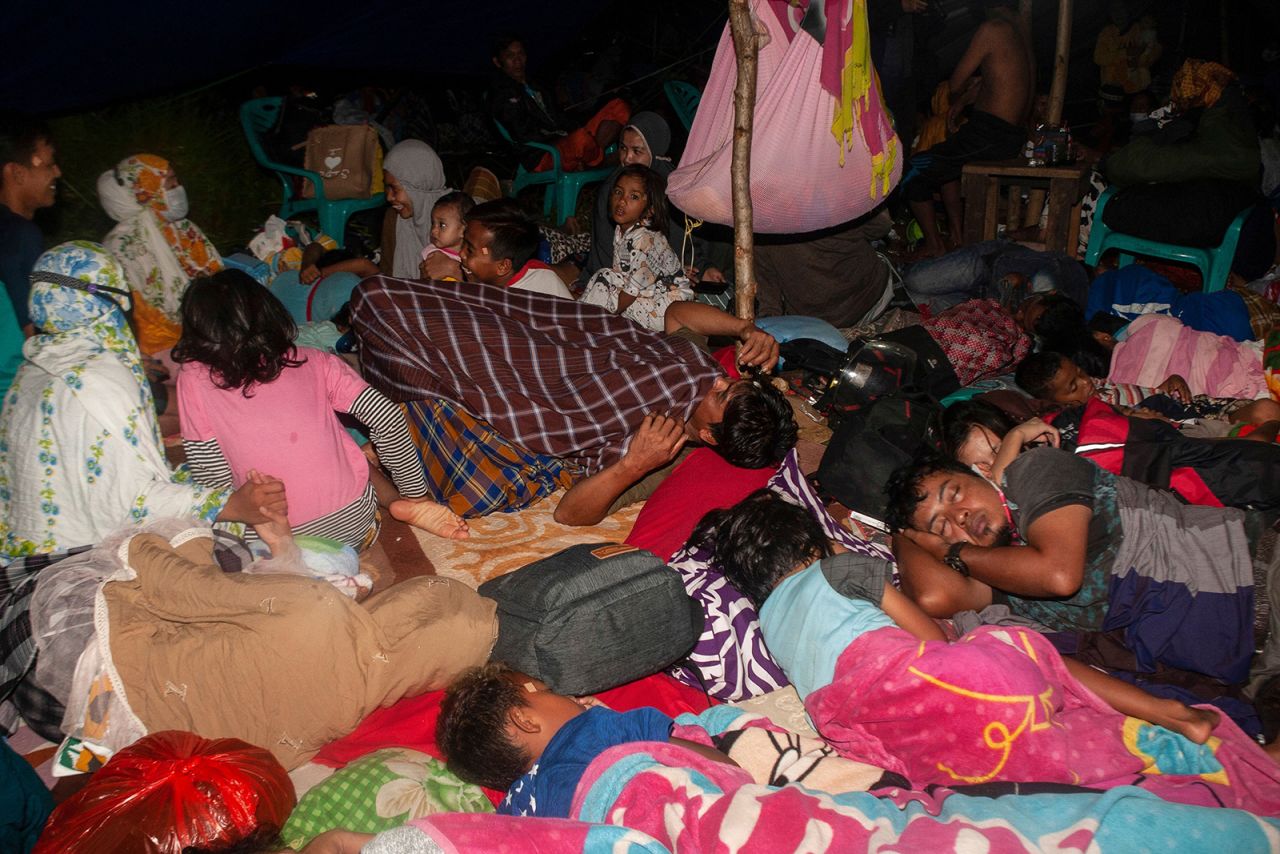 People rest inside a makeshift shelter in the aftermath of the earthquake in Mamuju.