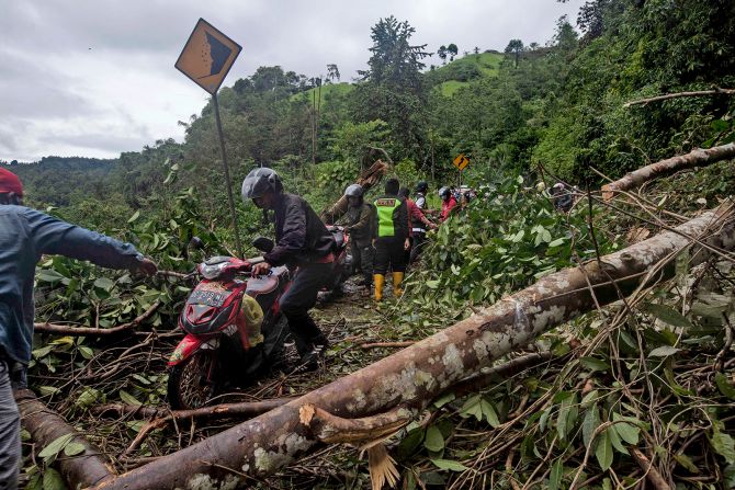 Motorists make their way through a road affected by an earthquake-triggered landslide near Mamuju.