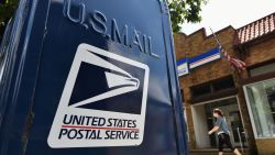 A woman walks past mailboxes  seen outside of a US Post Office in Washington, DC on August 17, 2020. - The United States Postal Service is popularly known for delivering mail despite snow, rain or heat, but it faces a new foe in President Donald Trump. Ahead of the November 3 elections in which millions of voters are expected to cast ballots by mail due to the coronavirus, Trump has leveled an unprecedented attack at the USPS, opposing efforts to give the cash-strapped agency more money as part of a big new virus-related stimulus package, even as changes there have caused delays in mail delivery. (Photo by MANDEL NGAN / AFP) (Photo by MANDEL NGAN/AFP via Getty Images)