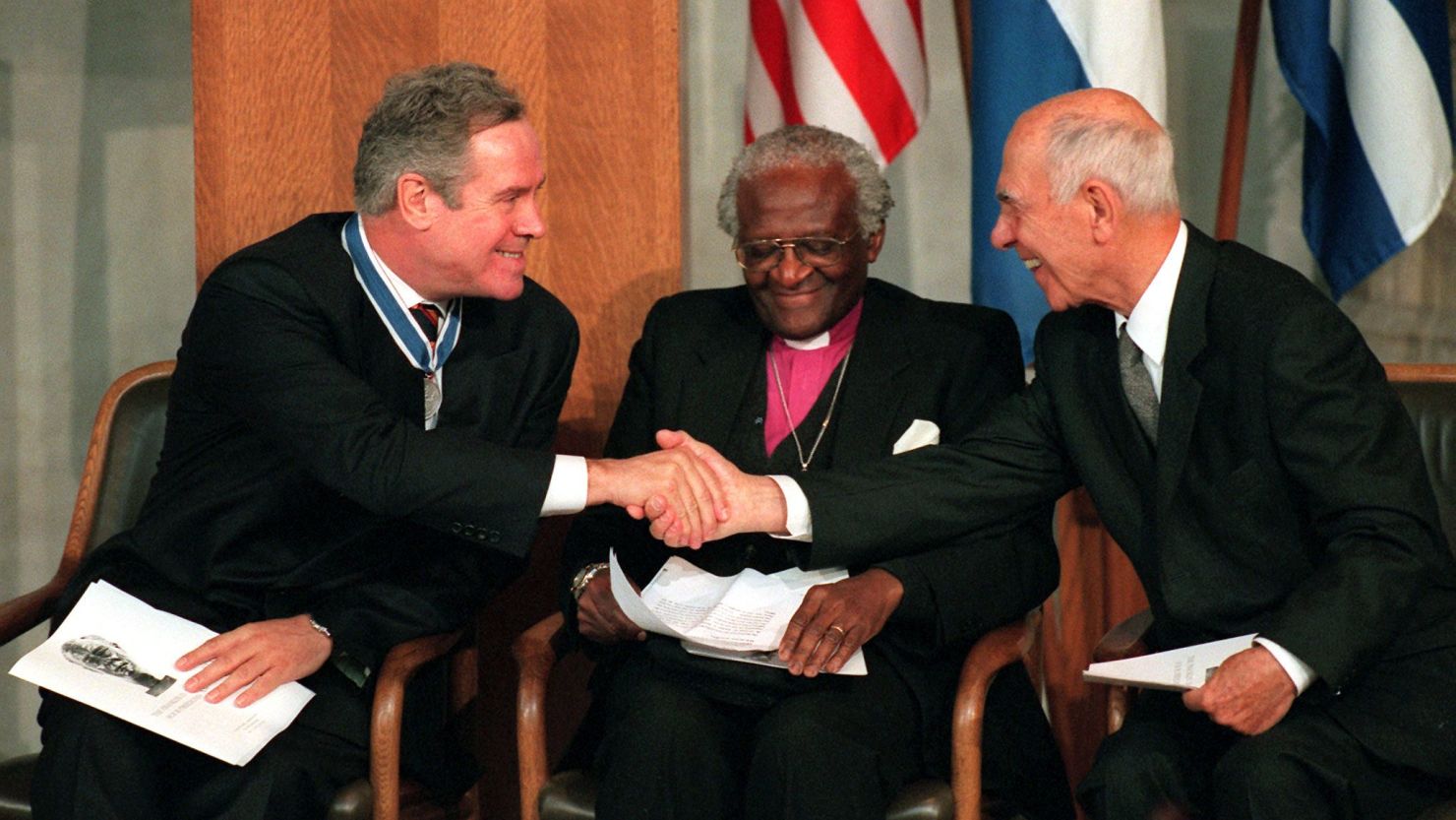 Chris Cramer (left), is congratulated by German-born former French ambassador Stephane Hessel (right) as Archbishop Desmond Tutu of South Africa smiles during a ceremony in the Netherlands in 1998 to present the Roosevelt Freedom Awards.