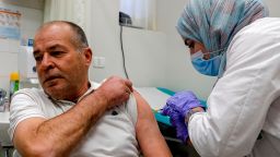 A Palestinian man gets vaccinated against the coronavirus at Clalit Health Services in the Palestinian neighbourhood of Beit Hanina, in the Israeli-annexed east Jerusalem, on January 12, 2021. (Photo by AHMAD GHARABLI / AFP) (Photo by AHMAD GHARABLI/AFP via Getty Images)