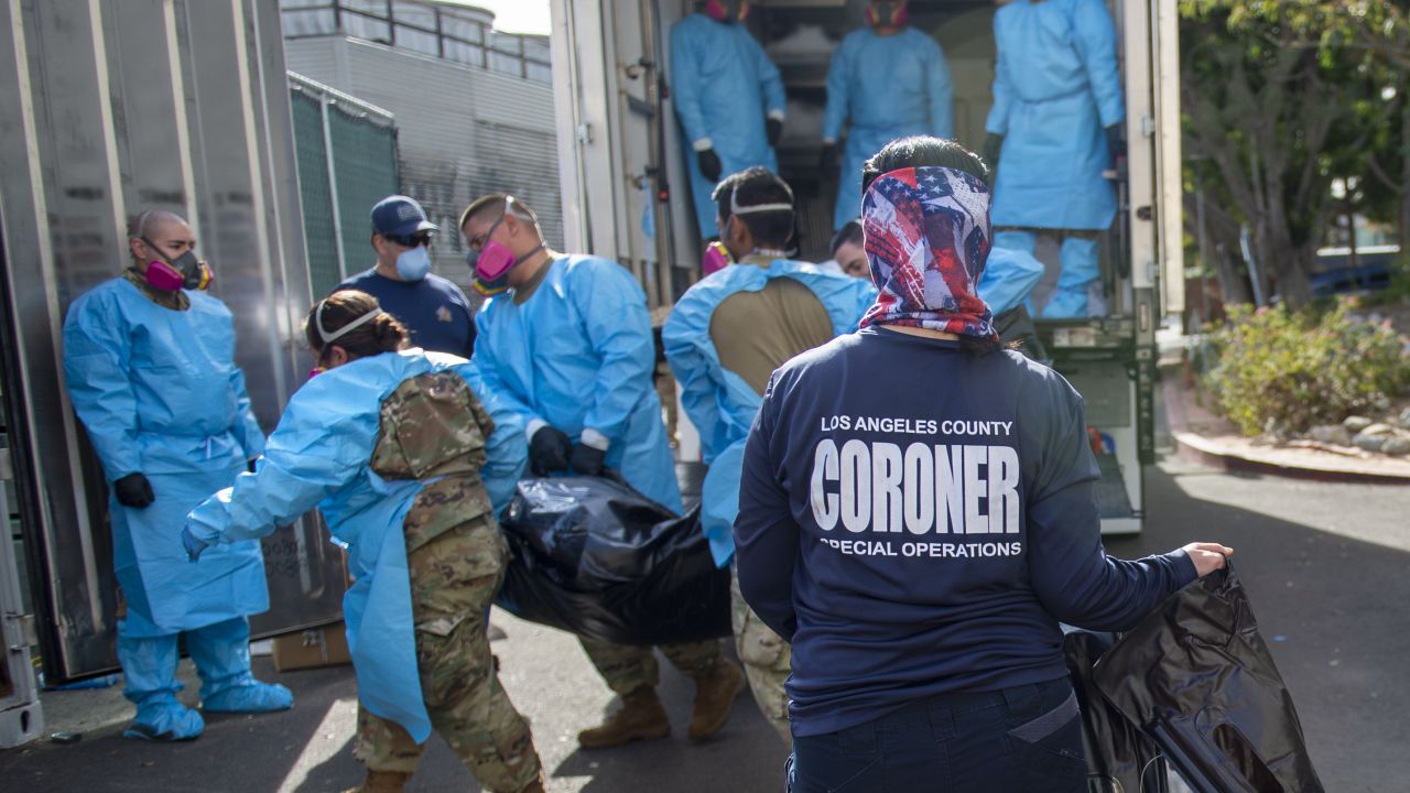Elizabeth Napoles, right, works with National Guardsmen who are helping to process Covid-19 deaths to be placed into temporary storage in Los Angeles on Tuesday, January 12.
