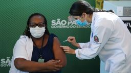 SAO PAULO, BRAZIL - JANUARY 17: Nurse Monica Calazans (54) receives the first CoronaVac vaccination shot in Brazil from Disease Control nurse and Master of Public Health at Santa Casa de Sao Paulo, Jessica Pires de Camargo, at Hospital das Clinicas of the University of Sao Paulo (USP) on January 17, 2021 in Sao Paulo, Brazil. Monica is part of the risk group and suffers from diabetes and hypertension, she works in the Intensive Care Unit (ICU) of Emilio Ribas, a reference in the treatment of infectious diseases. The CoronaVac vaccine was developed by the Chinese laboratory Sinovac in partnership with the Butantan Institute. The National Health Surveillance Agency (Anvisa) authorized today the emergency use of the CoronaVac and the AstraZeneca (developed by the University of Oxford in partnership with the Oswaldo Cruz Foundation (Fiocruz) vaccines against Covid-19. (Photo by Rodrigo Paiva/Getty Images)