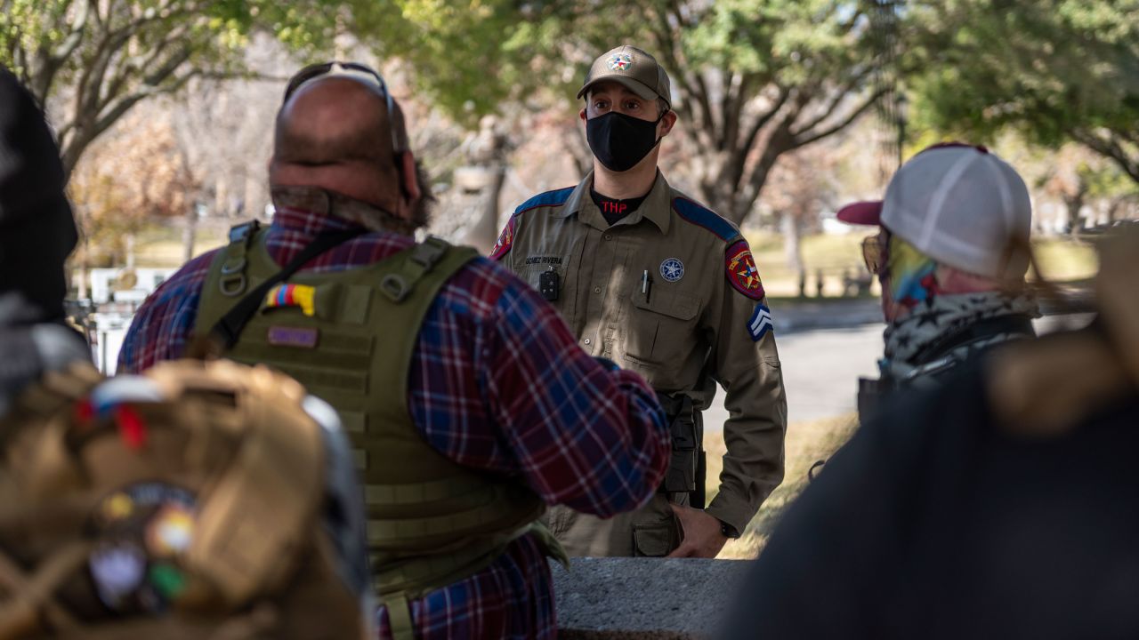 An officer speaks Sunday to a small group of anti-government, pro-gun demonstrators outside the Texas state Capitol in Austin.