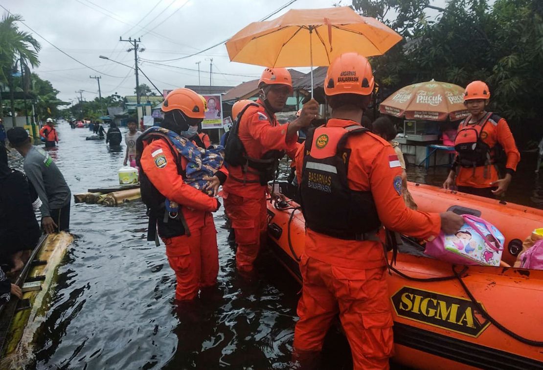 Rescuers evacuate people from a flooded residential area in Banjarbaru, South Kalimantan, Borneo Island, on 17 January 2021. 
