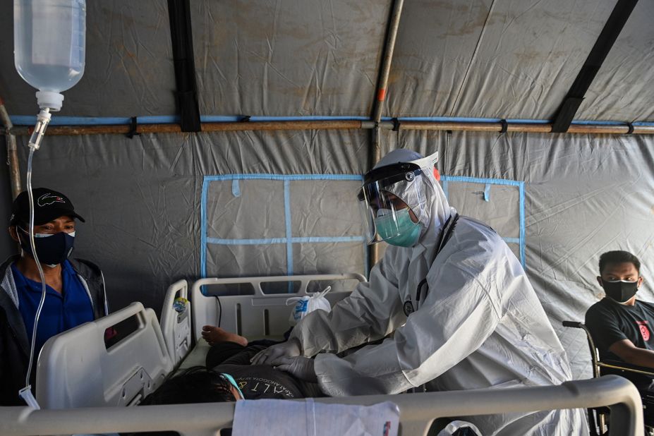 A patient injured in the earthquake receives treatment at a makeshift ward outside a regional hospital due to concerns of aftershocks in Mamuju.