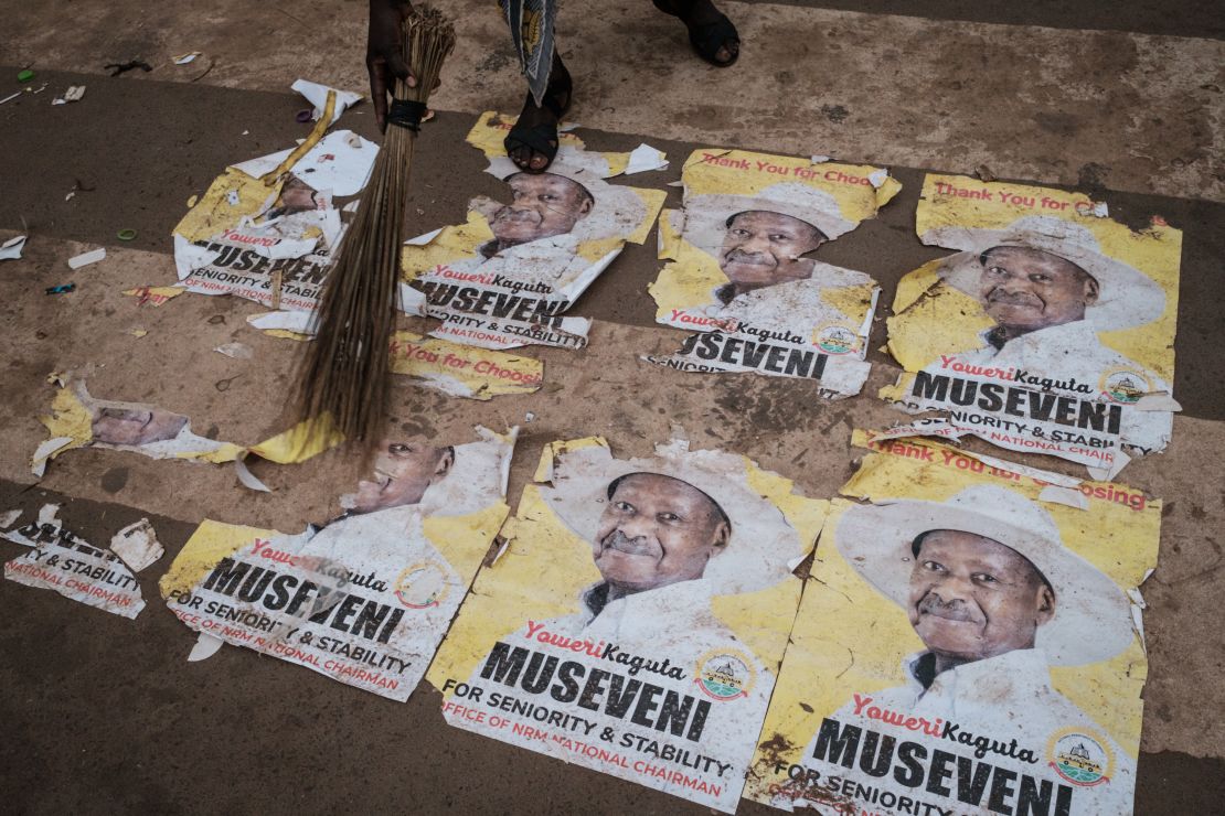 A worker sweeps a street in Kampala covered with posters of Museveni a day after the election commission said he won a sixth term in office.