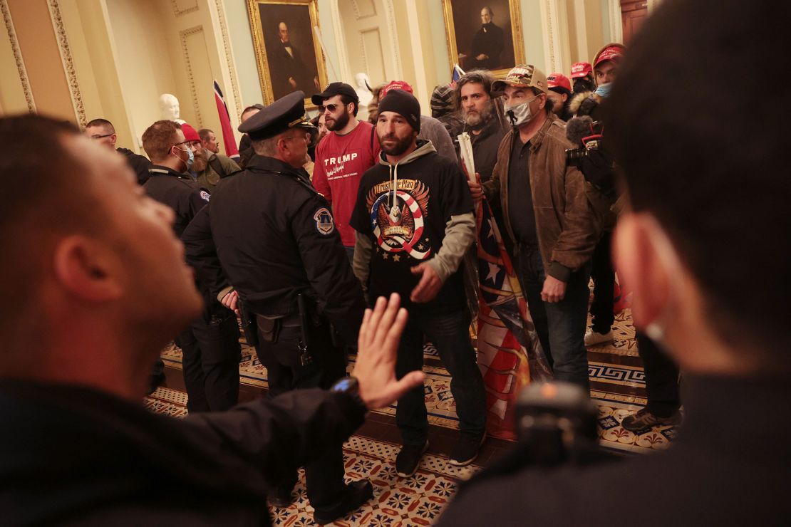 Protesters interact with Capitol Police inside the US Capitol Building. 