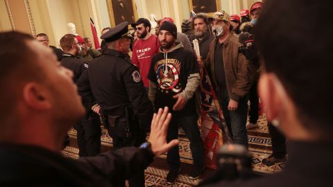 Protesters interact with Capitol Police inside the US Capitol Building. 