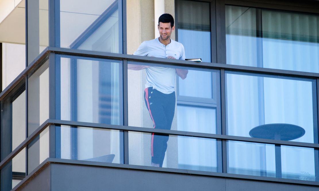 Serbia's Novak Djokovic stands on the balcony at his accommodation in Adelaide, Australia, on January 19, 2021. 
