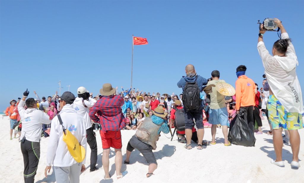 <strong>Flag-raising ceremony:</strong> As part of the cruises, travelers hear patriotic stories -- usually the version of history told from the perspective of the ruling Chinese Communist Party -- and take part in a flag-raising ceremony on one of the islands. This photograph was taken during a ceremony on Quanfu Island in 2016.