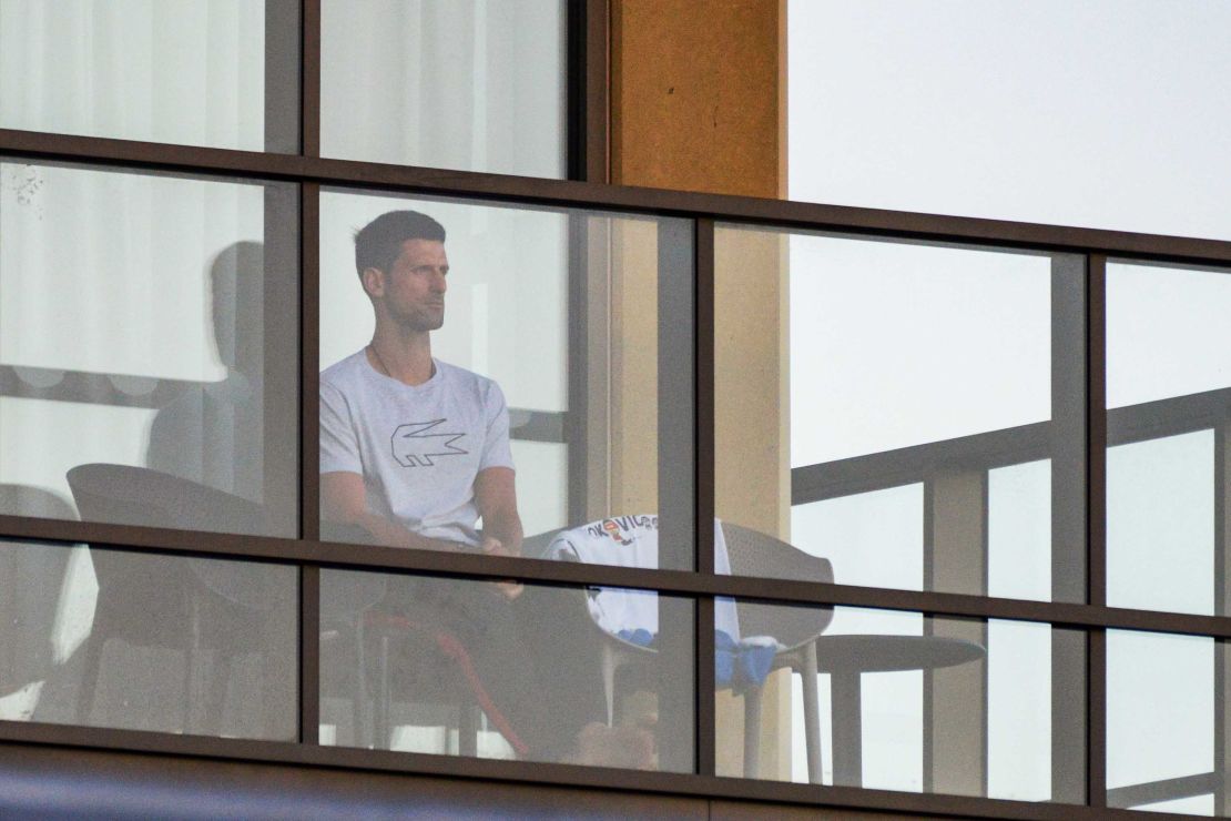 Men's singles world number one tennis player Novak Djokovic of Serbia sits on his hotel balcony in Adelaide, Australia, on January 18, one of the locations where players have quarantined for two weeks upon their arrival ahead of the Australian Open tennis tournament in Melbourne.