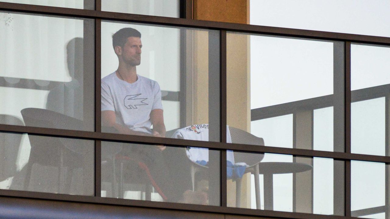 Men's singles world number one tennis player Novak Djokovic of Serbia sits on his hotel balcony in Adelaide, Australia, on January 18, one of the locations where players have quarantined for two weeks upon their arrival ahead of the Australian Open tennis tournament in Melbourne.