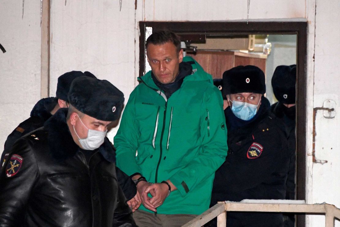 Navalny is escorted out of a police station on January 18, 2021, in Khimki, outside Moscow, following a court ruling that ordered him jailed for 30 days.