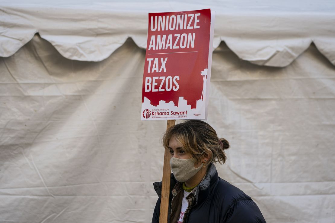 A demonstrator holds a sign reading "Tax Bezos" during a protest outside Amazon.com headquarters in Seattle, Washington in November.