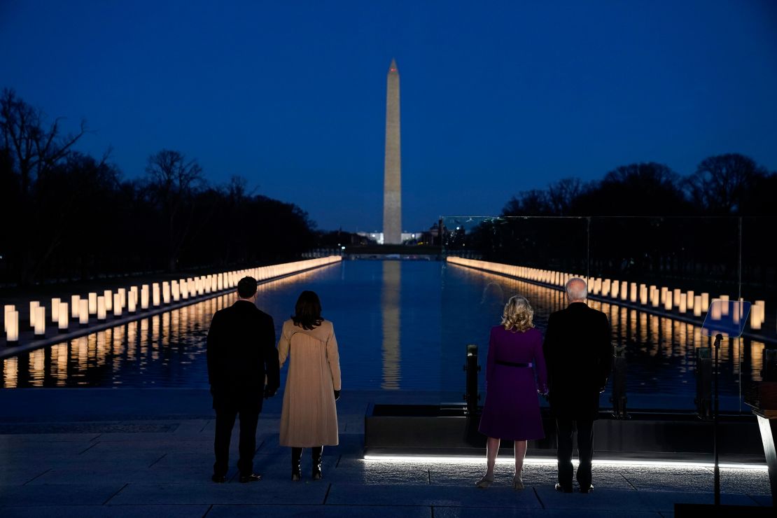 With the Washington Monument in the background, President-elect Joe Biden with his wife Jill Biden and Vice President-elect Kamala Harris with her husband Doug Emhoff listen as Yolanda Adams sings "Hallelujah" during a COVID-19 memorial, with lights placed around the Lincoln Memorial Reflecting Pool, Tuesday, Jan. 19, 2021, in Washington. (AP Photo/Evan Vucci)