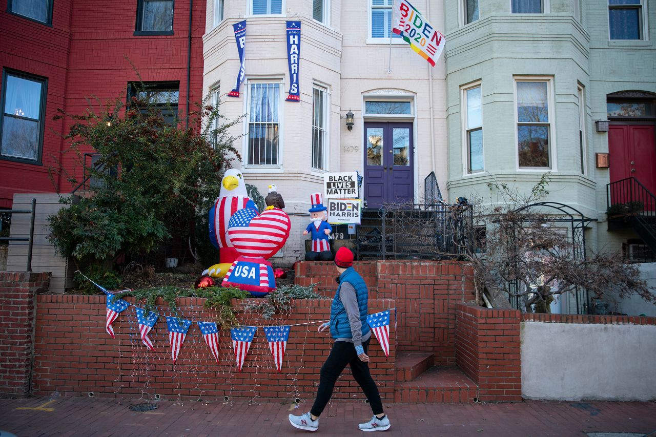 A man walks past a home in Washington, DC, that was decorated in support of Biden and Harris.