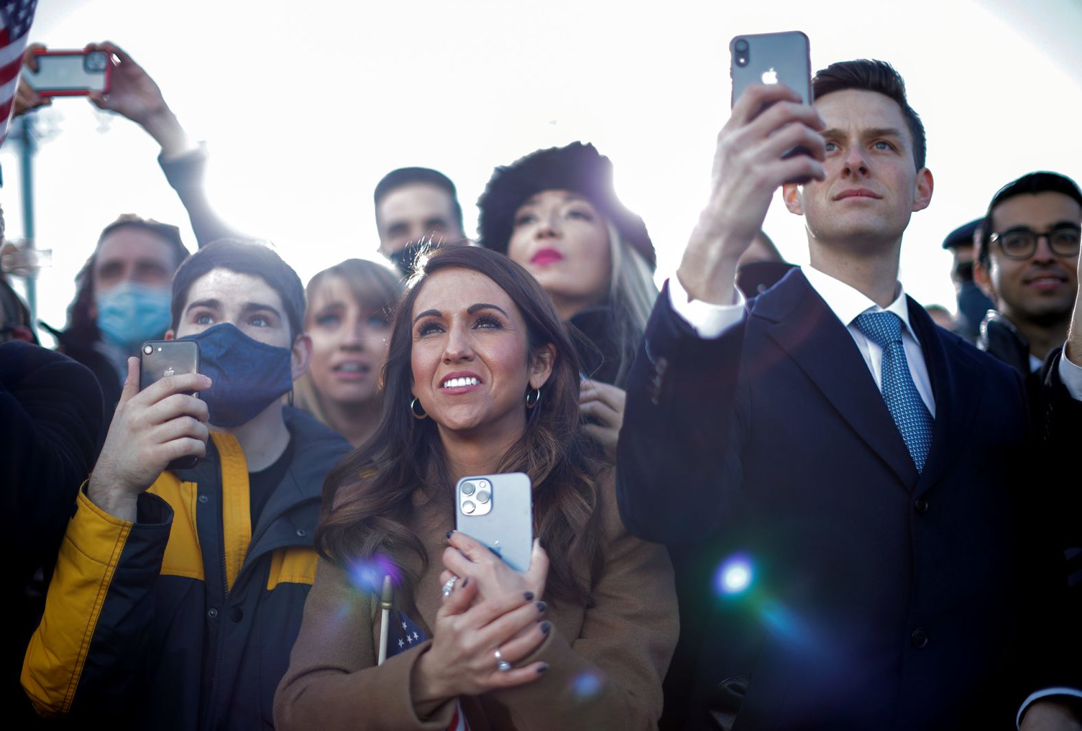 People watch Trump's farewell at Joint Base Andrews. Holding the phone in the center is US Rep. Lauren Boebert, one of the Republicans who voted against the counting of Electoral College votes for Biden.