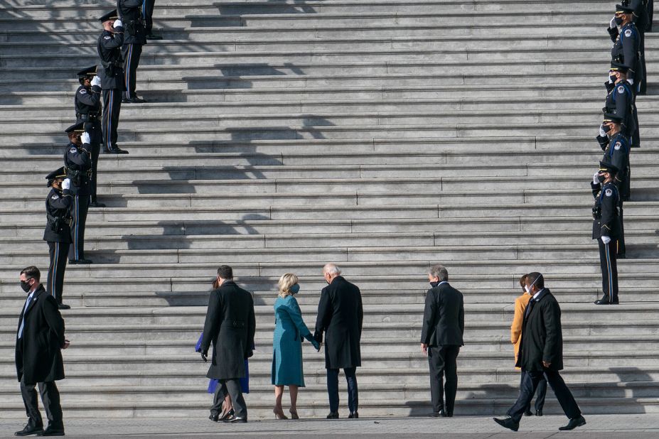 The Bidens hold hands before walking up the Capitol steps.