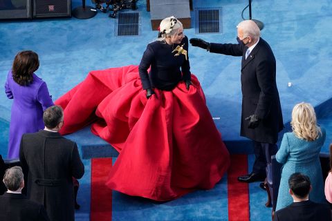 Biden greets Lady Gaga, who was wearing a golden broach in the shape of a dove.