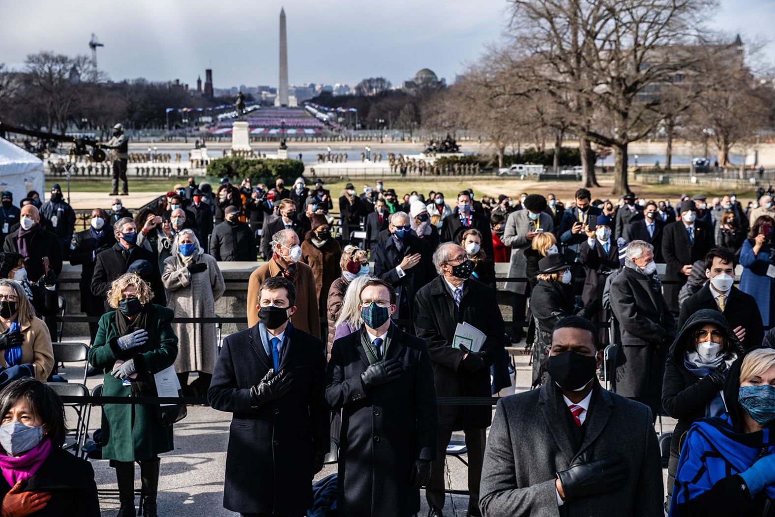 Guests stand for the National Anthem. At center is former presidential candidate Pete Buttigieg and his husband, Chasten. Buttigieg was <a href="https://www.cnn.com/2020/12/15/politics/pete-buttigieg-transportation-secretary/index.html" target="_blank">Biden's pick for transportation secretary.</a>