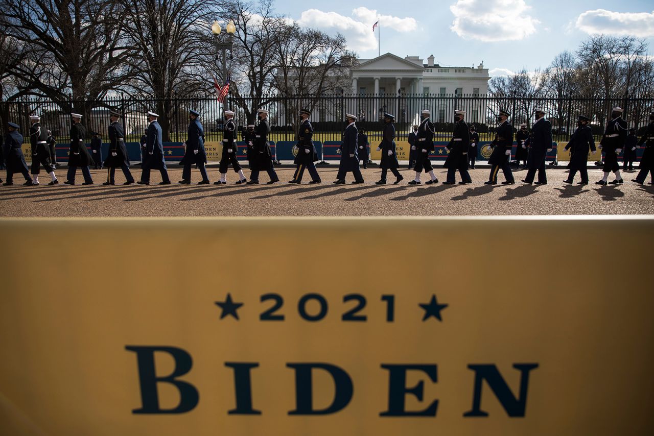 Members of the military walk past the White House during Biden's abbreviated parade.