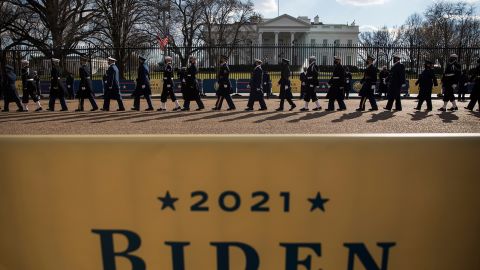 Members of the military walk past the White House during Biden's abbreviated parade.