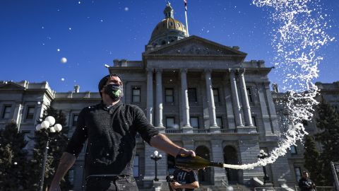 Keith Hodson pops a bottle of champagne on the steps of the Colorado State Capitol in Denver.