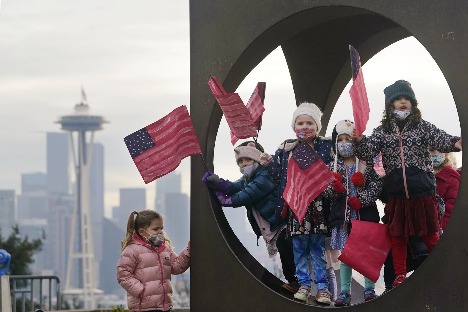 Members of the Children's Workshop, an arts and science preschool in Seattle, pause in a sculpture while walking with flags they made to celebrate the inauguration.