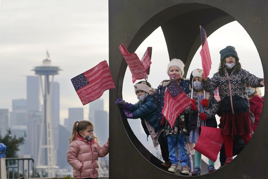 Members of the Children's Workshop, an arts and science preschool in Seattle, pause in a sculpture while walking with flags they made to celebrate the inauguration.