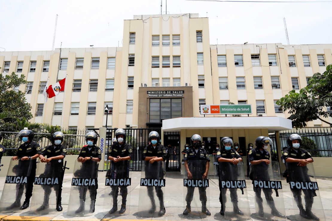 Police stand guard outside the Ministry of Health as health workers protest in Peru on January 13.