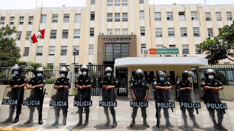 Police stand guard outside the Ministry of Health as health workers protest in Peru on January 13.