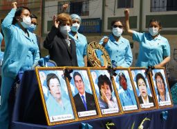 Health workers in the highland city of Puno in the Andes, protest with pictures of their co-workers who died during the pandemic in August.