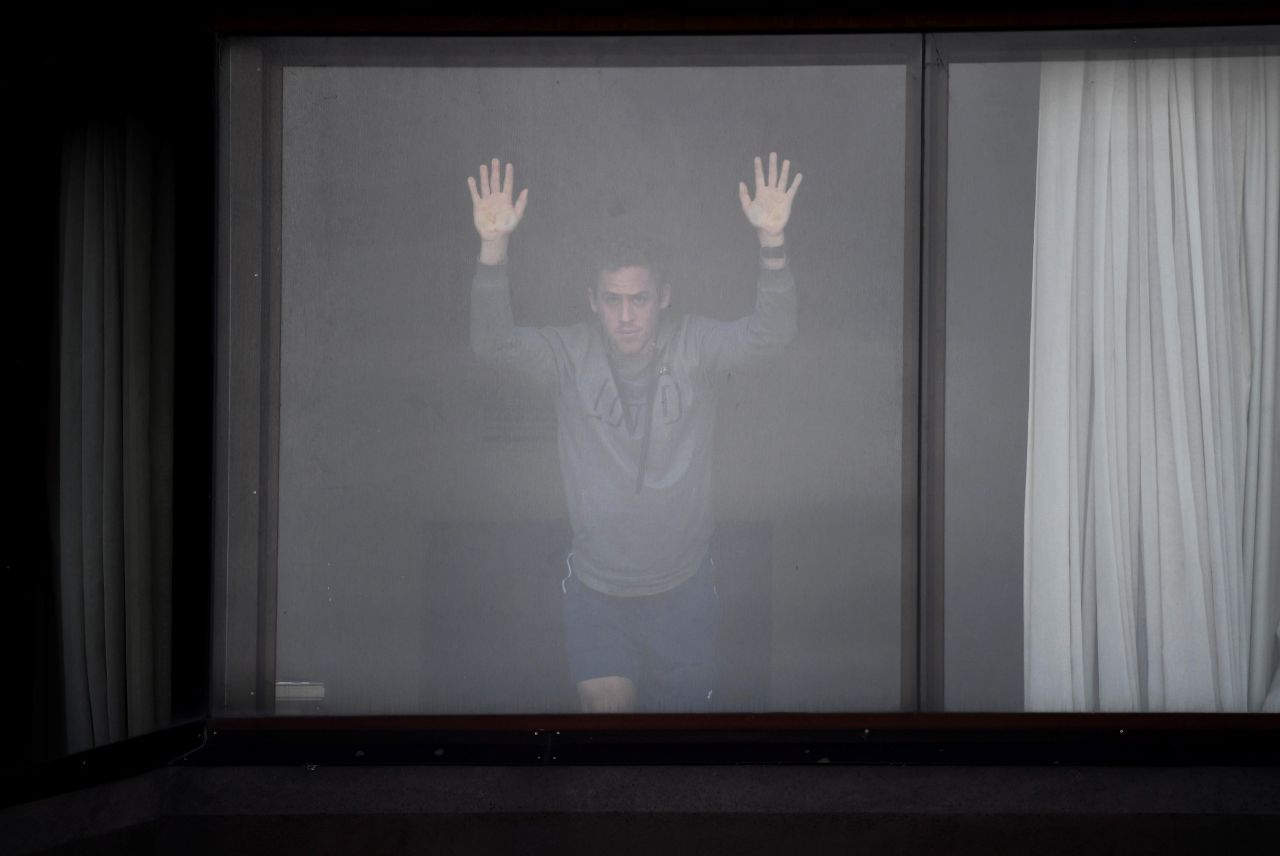 A tennis player waits for a training session from his hotel in Melbourne on Tuesday, January 19. Dozens of players have had to quarantine in hotels ahead of the Australian Open, and a number of them <a href="https://www.cnn.com/2021/01/17/tennis/australian-open-covid-19-spt-intl/index.html" target="_blank">have vocally expressed their frustrations.</a>