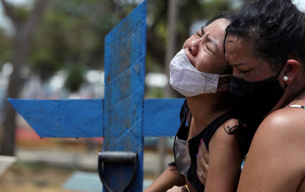 Kelvia Andrea Goncalves, left, is supported by her aunt Vanderleia dos Reis Brasao during the burial of her mother, Andrea dos Reis Brasao, in Manaus, Brazil, on Sunday, January 17. Andrea, 39, died from Covid-19.