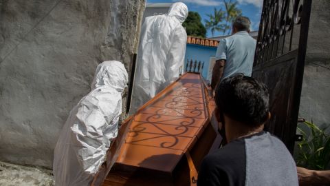 Municipal workers remove the body of 75-year-old Adamor Mendonca Maciel from his home in Manaus, Brazil, on January 16, 2021 after he died of Covid-19.