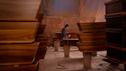 A worker sprays a wood coffin at the Enzo Wood Designs manufacturing facility in Johannesburg, South Africa, on January 20, 2021.