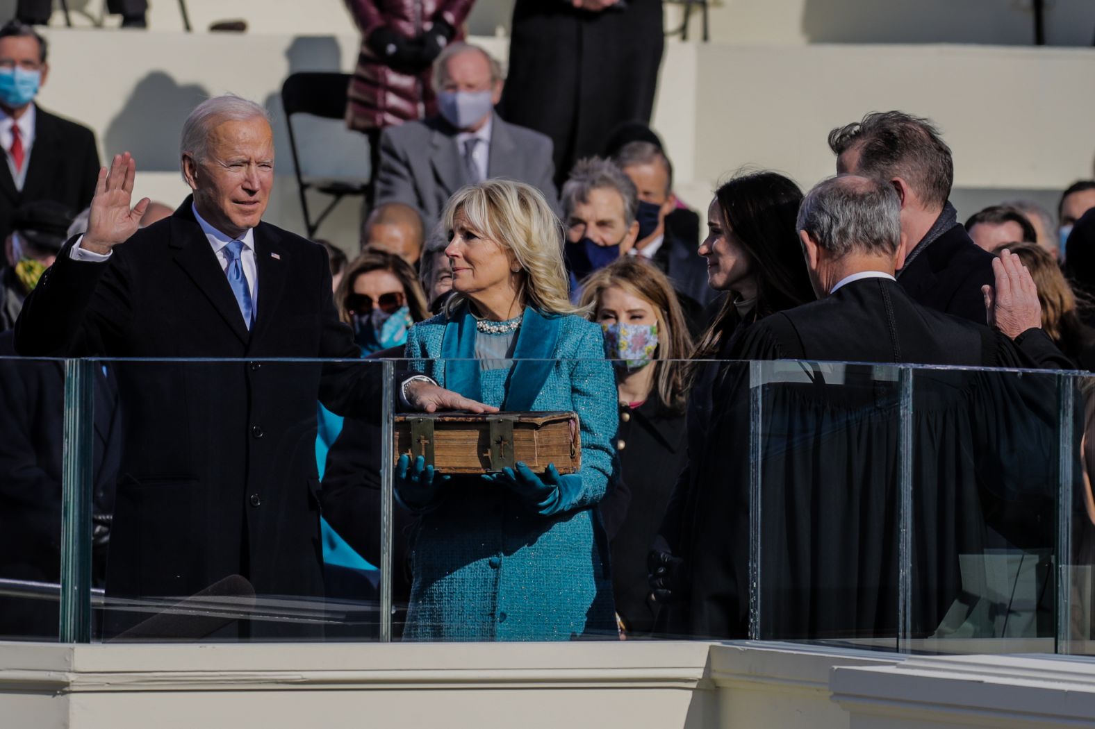 Biden raises his right hand as he takes the oath of office.