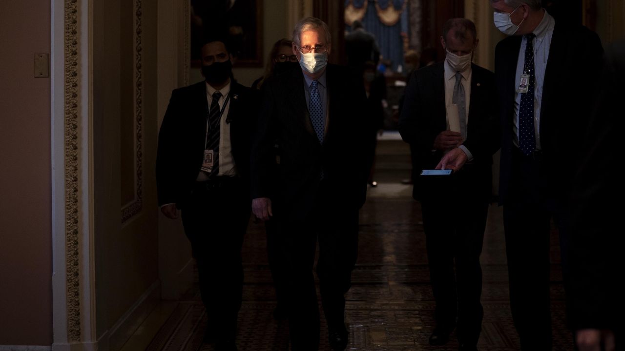 Senate Minority Leader Mitch McConnell, center, wears a protective mask while walking to his office from the Senate Chamber at the U.S. Capitol in Washington, D.C., U.S., on Thursday, Jan. 21, 2021.