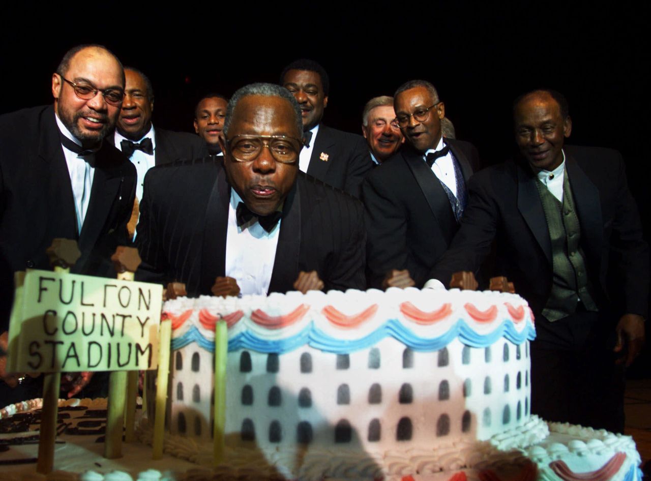 Aaron blows out candles for his 65th birthday in 1999. Behind him are many baseball greats: from left, Reggie Jackson, Frank Robinson, Sammy Sosa, Don Baylor, Phil Niekro, Sonny Jackson and Ernie Banks.