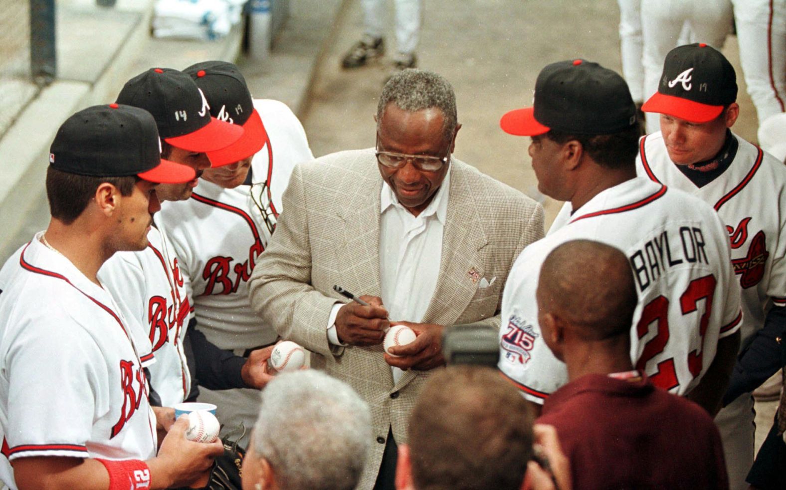 Aaron signs autographs for some of the Atlanta Braves in 1999.