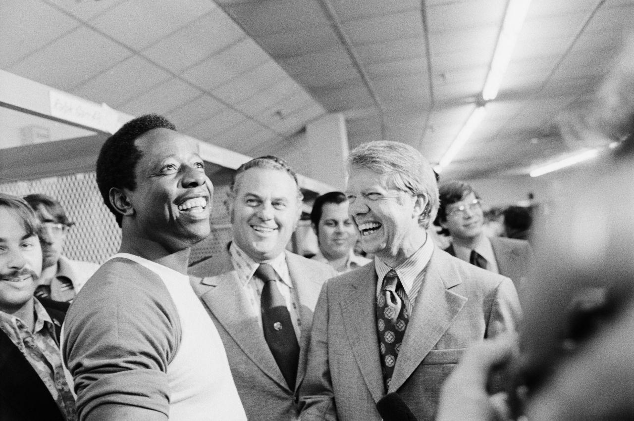 Future US President Jimmy Carter, then the governor of Georgia, laughs with Aaron during a clubhouse visit in 1973.