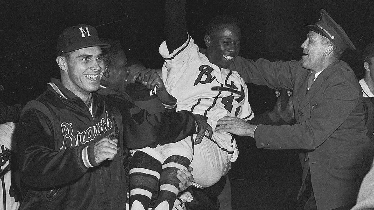 Aaron is carried from the field by his Milwaukee Braves teammates after they won the National League pennant in 1957. 