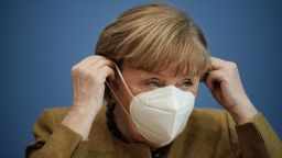 German Chancellor Angela Merkel puts on her face mask after giving a press conference on the Covid-19 situation in Germany at the house of the Federal Press Conference (Bundespressekonferenz), on January 21, 2021 in Berlin. (Photo by Michael Kappeler / POOL / AFP) (Photo by MICHAEL KAPPELER/POOL/AFP via Getty Images)