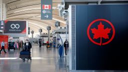 TORONTO, ON - APRIL 01: A passenger wheels his luggage near an Air Canada logo at Toronto Pearson International Airport on April 1, 2020 in Toronto, Canada. Air Canada announced it would temporarily lay off over 15,000 employees and reduce activity by up to 90 percent due to the coronavirus. (Photo by Cole Burston/Getty Images)