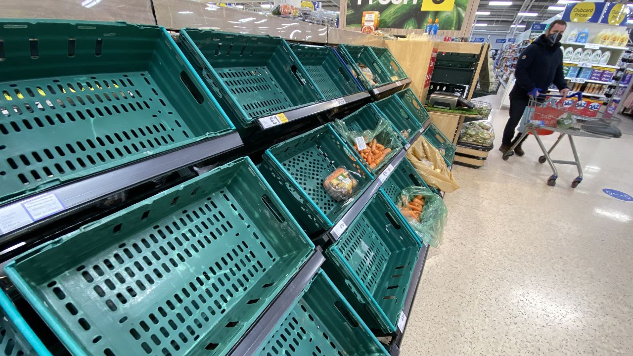 A supermarket customer looks at the near empty shelves in Tescos on January 14, 2021 in Belfast, Northern Ireland. 